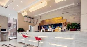 a restaurant with red stools in a lobby at GreenTree Inn Nantong University Industrial Expo City Express Hotel in Dexingzhen