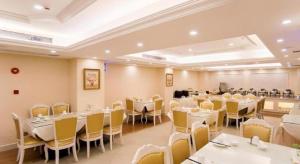 ein Restaurant mit weißen Tischen und gelben Stühlen in der Unterkunft Vienna 3 Best Shanghai Baoshan Fengxiang Road in Chenjiahang