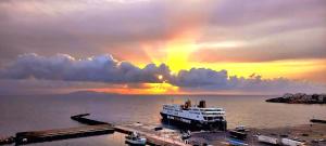un bateau de croisière sur l'eau avec un arc-en-ciel dans l'établissement Aelia Sea View Apartments Rafina close to the Port , Airport & Athens, à Rafína