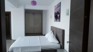 ママイアにあるApartament Sophia Mamaiaのベッドルーム(白いベッド1台、枕付)