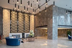 eine Lobby mit einer Couch, Stühlen und einem Tisch in der Unterkunft hailihotel in Dongguan