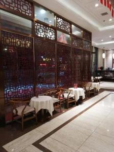 a dining room with tables and chairs in a restaurant at Kaibin International Hotel Jingdezhen in Jingdezhen