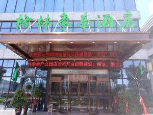 a building with a sign on top of it at GreenTree Inn Bozhou Qiaocheng District Bowu Industrial Park Business Hotel in Bozhou