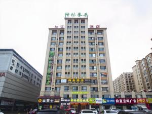 ein hohes Gebäude in einer Stadt mit Autos in der Unterkunft GreenTree Inn Weifang Kuiwen District Beiwang Jiale in Weifang