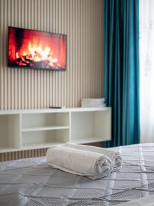 een bed met een handdoek erop en een open haard bij Everest Home in Alma-Ata +81 foto's