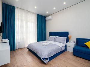 een slaapkamer met een bed en een blauwe stoel bij Everest Home in Alma-Ata