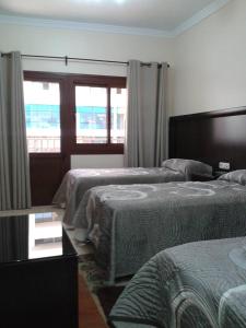um quarto de hotel com duas camas e uma janela em Hotel Mediterranee em Nador