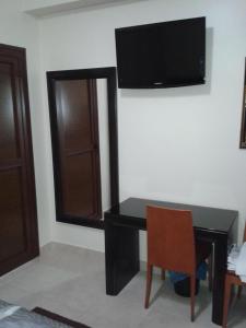 einen schwarzen Schreibtisch mit einem Stuhl und einem TV an der Wand in der Unterkunft Hotel Mediterranee in Nador