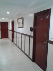 um corredor com duas portas de madeira e uma parede em Hotel Mediterranee em Nador