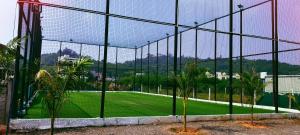 - une vue sur un court de tennis à travers une clôture dans l'établissement Amigos, à Annavaram