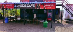 un stand de boissons avec des chaises et une enseigne Coca-Cola dans l'établissement Amigos, à Annavaram