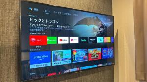 a television screen on a wall with japanese signs at GRAND BASE Hakataminami in Fukuoka