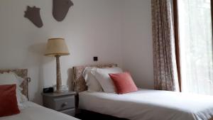 a bedroom with two beds and a window at La Pantoufle Verte in Montauriol