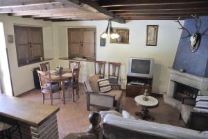 a living room with a couch and a table and a tv at La casina de Berdayes in Labra