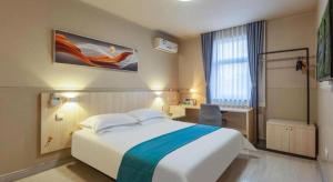 a hotel room with a large bed and a window at Jinjiang Inn Taiyuan Longtan Park in Taiyuan