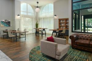a living room with a couch and tables and chairs at The Hamilton Alpharetta, Curio Collection By Hilton in Alpharetta