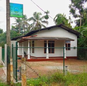 a small white house behind a fence at CYT VILLA - Ja Ela in Ja-Ela