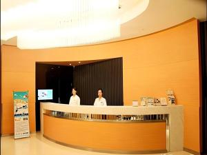 two people standing at the counter of a restaurant at Jinjiang Inn Dalian Development Zone Jinma Road Light Railway Station in Jinzhou