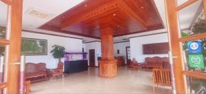 a living room with chairs and a large wooden pillar at Domi Hotel in Siem Reap