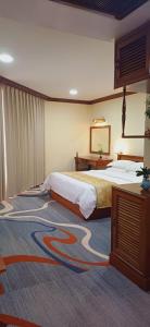 a bedroom with a large bed and a carpet at Domi Hotel in Siem Reap