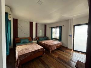 una stanza con due letti e una finestra di Roomy Bungalows a Phumĭ Kâoh Rŏng