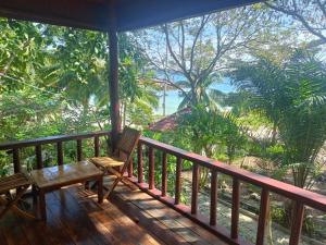 un portico con panchina e vista sull'oceano di Roomy Bungalows a Phumĭ Kâoh Rŏng