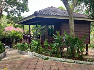 una piccola cabina in legno con portico e alcune piante di Roomy Bungalows a Phumĭ Kâoh Rŏng Altre 7 foto