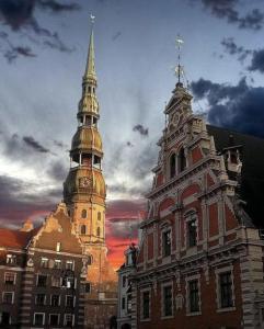ein Gebäude mit einem Uhrenturm darauf in der Unterkunft Vintage-style apartments in the historic center in Riga