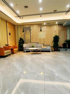 a lobby with couches and tables in a building at GreenTree Inn HanZhong Railway Station Beiyihuan Road Express Hotel in Shima