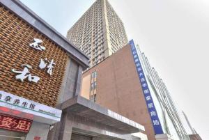 a building with two tall buildings in a city at LAVANDE Hotel Dalian Huanan Square North Railway Station in Dalian