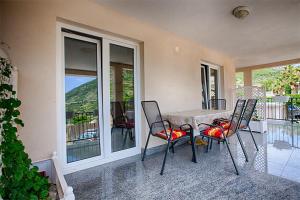 a table and chairs in a house with a balcony at Apartments Nikola Vidović in Komiža