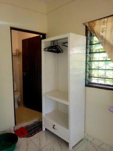 a white cabinet in a room with a bathroom at Cozy studio in Malindi