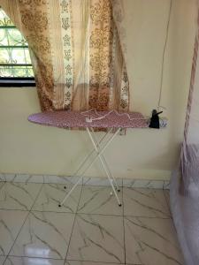 a room with a table in a room with a window at Cozy studio in Malindi