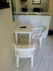 a white table and two white chairs in a kitchen at Cozy studio in Malindi