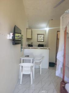 a kitchen with two white chairs and a table at Cozy studio in Malindi