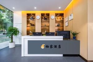 an office with a reception desk and clocks at UHotelPhoenixInternationalAirport in Sanya