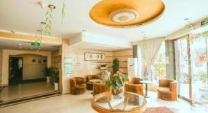 a living room with a glass table and chairs at GreenTree Inn Yangzhou Slender West Lake Wencheng Attic Express Hotel in Yangzhou