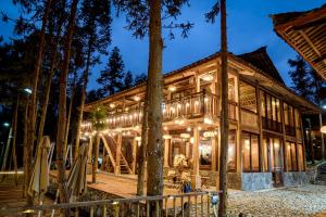 a log cabin in the woods at night at Balana HaGiang in Làng Lap