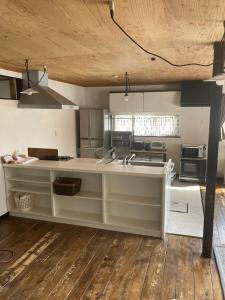 eine Küche mit weißen Schränken und einem Holzboden in der Unterkunft Cottage Akagera in Wada