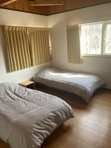 ein Schlafzimmer mit zwei Betten und einem Fenster in der Unterkunft Cottage Akagera in Wada