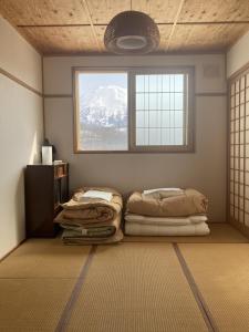 zwei Betten in einem Zimmer mit Fenster in der Unterkunft Cottage Akagera in Wada