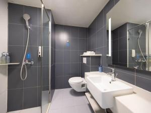 ein Badezimmer mit Toilette, Waschbecken und Dusche in der Unterkunft Hanting Hotel Beijing Daxing New Town Jinxing Bridge in Peking + 23 Fotos