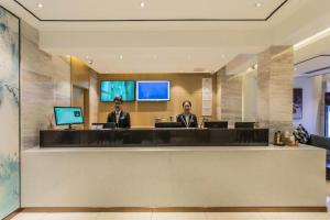 2 hommes assis à la réception dans le hall dans l'établissement City Comfort Inn Guilin Railway Station, à Guilin