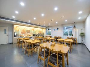 ein Esszimmer mit Holztischen und Stühlen in der Unterkunft Hanting Hotel Beijing Daxing New Town Jinxing Bridge in Peking