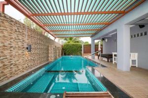 ein Swimmingpool in einem Haus mit einer Ziegelmauer und einem Swimmingpoolasteryastery in der Unterkunft OYO 121 Hua Hin Goodview in Hua Hin