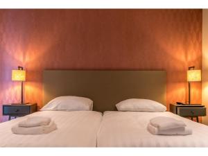 zwei Betten in einem Zimmer mit zwei Handtüchern darauf in der Unterkunft Modern villa in De Cocksdorp near the beach in De Cocksdorp