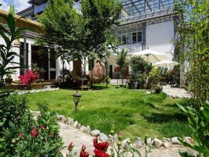 ein Haus mit einem Garten mit Blumen im Hof in der Unterkunft Dali Five Elements Hostel in Dali