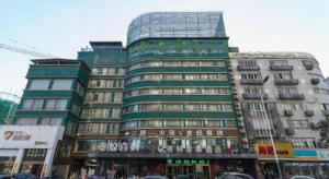 un grand bâtiment de grande hauteur avec beaucoup de fenêtres dans l'établissement GreenTree Inn Xuzhou South Minzhu Road, à Xuzhou