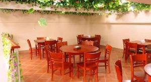 a restaurant with wooden tables and chairs and plants at GYA Hotel Shanghai Songjiang Wanda Plaza in Songjiang