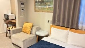 a hotel room with a bed and a chair at GRAND BASE Hakataminami in Fukuoka +15 photos